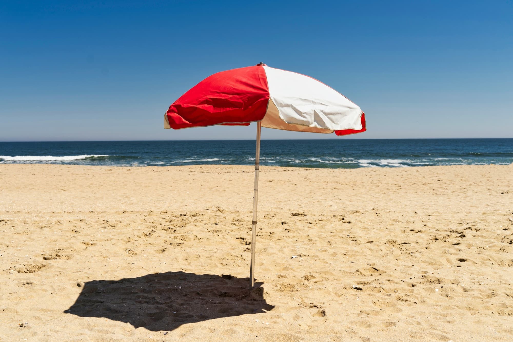 Red and white umbrella on an empty beach
